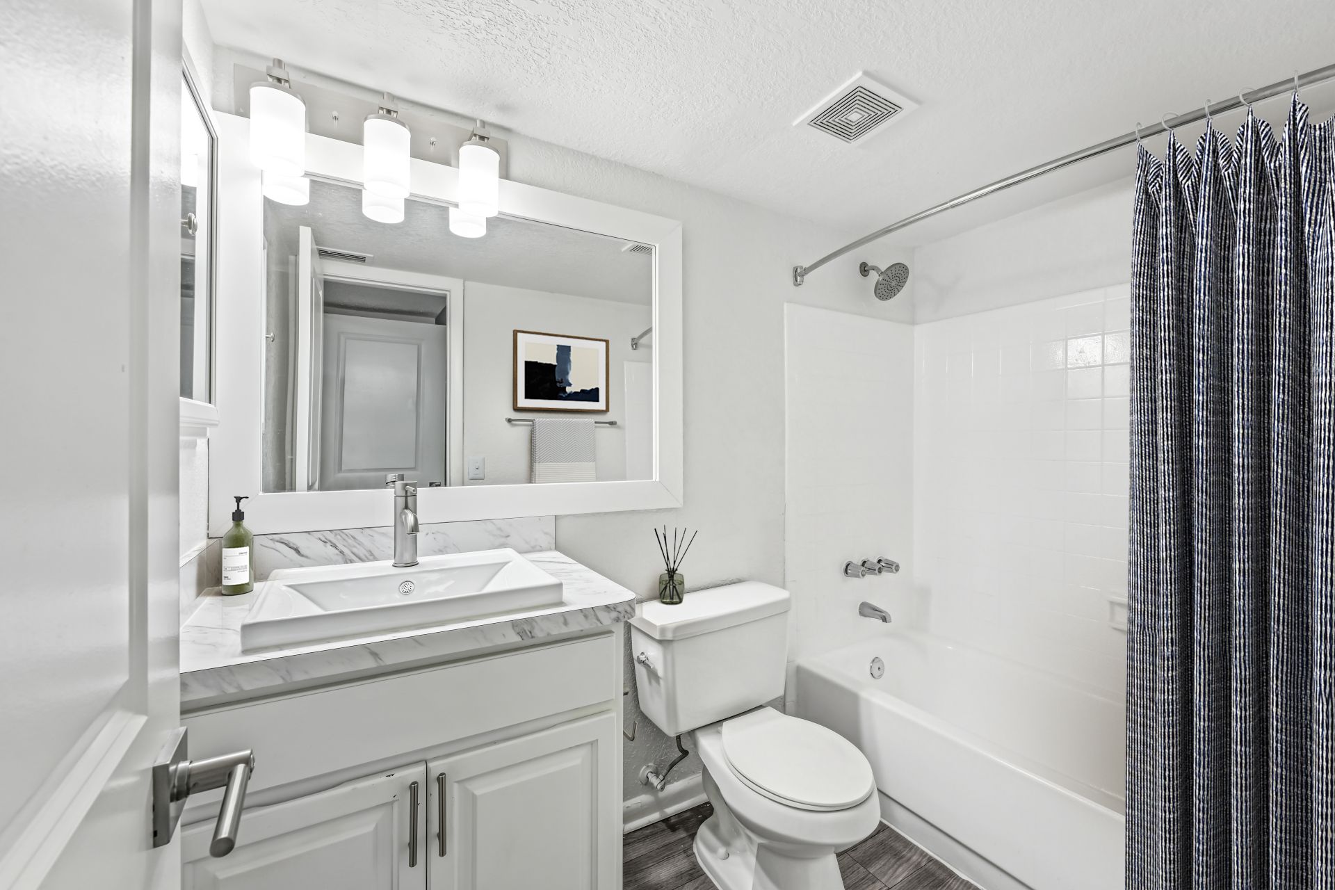Bright and modern bathroom with elegant marble countertop, sleek fixtures, and stylish lighting, creating a luxurious spa-like atmosphere.